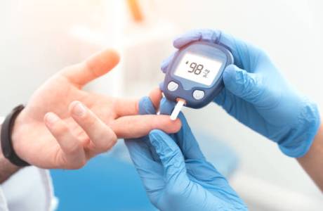 Doctor checking blood sugar level with glucometer. Treatment of diabetes concept.